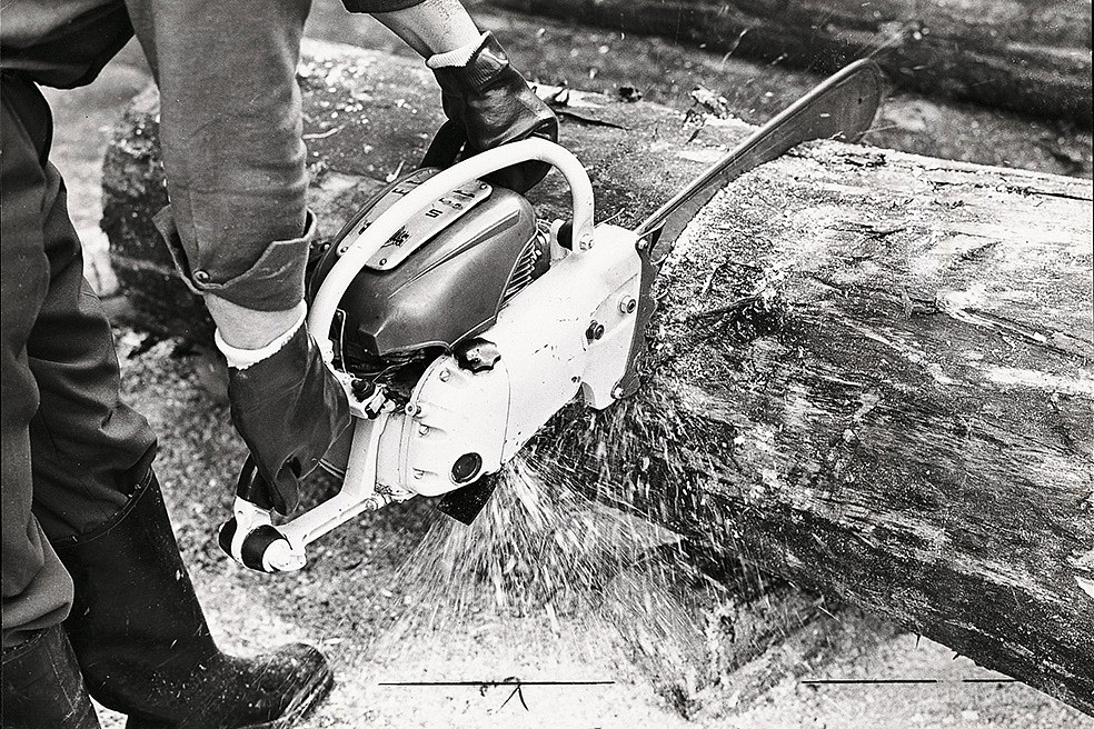 Vue d’époque d’une STIHL Contra utilisée pour le tronçonnage d’un tronc.