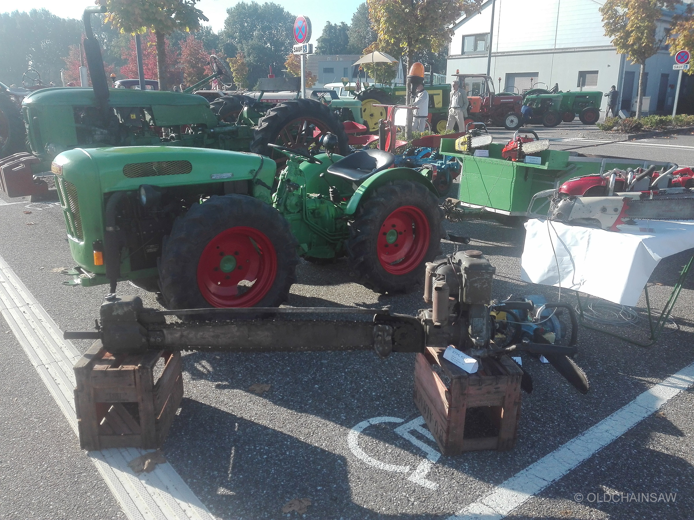 La STIHL KS 43 présentée sur d’anciennes caisses en bois, devant notre tracteur et les autres machines réunies à l’extérieur de l’Espace W.