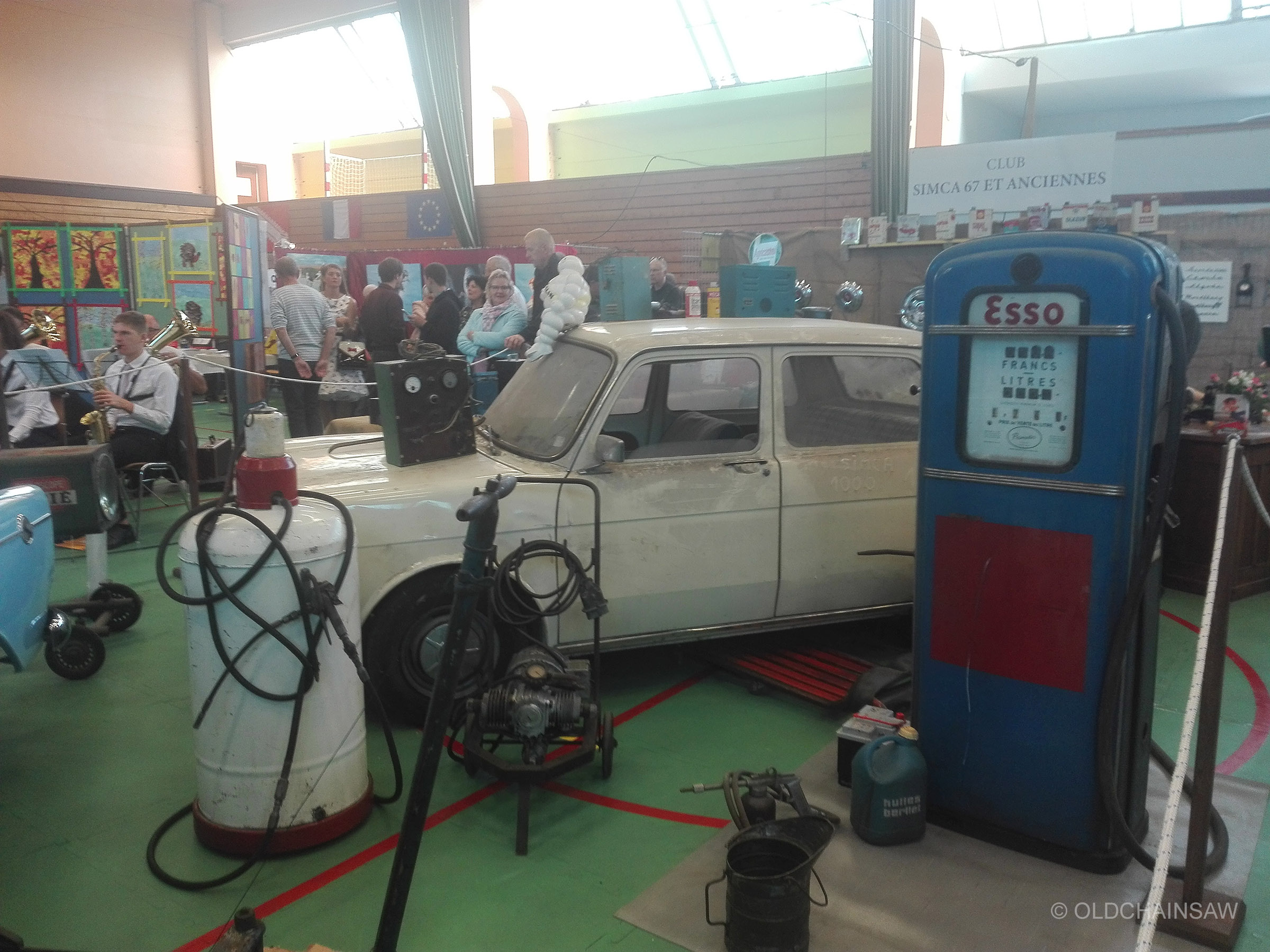 Reconstitution d’un atelier mécanique d’autrefois par le Club SIMCA 67, avec automobile, pompes à carburant et accessoires de garage anciens.
