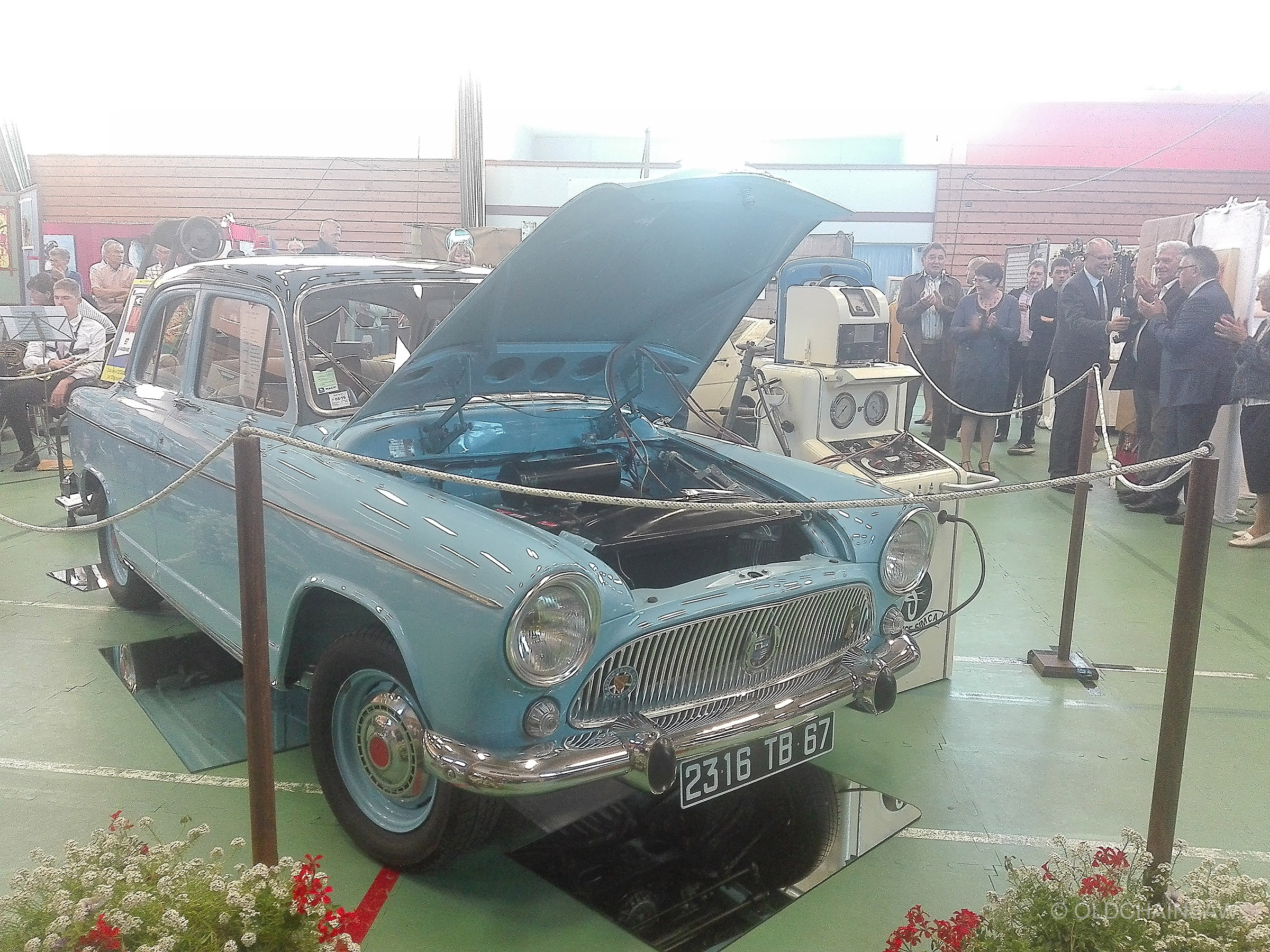 Automobile SIMCA présentée capot ouvert dans le décor de l’atelier mécanique reconstitué à l’intérieur de l’Espace W.