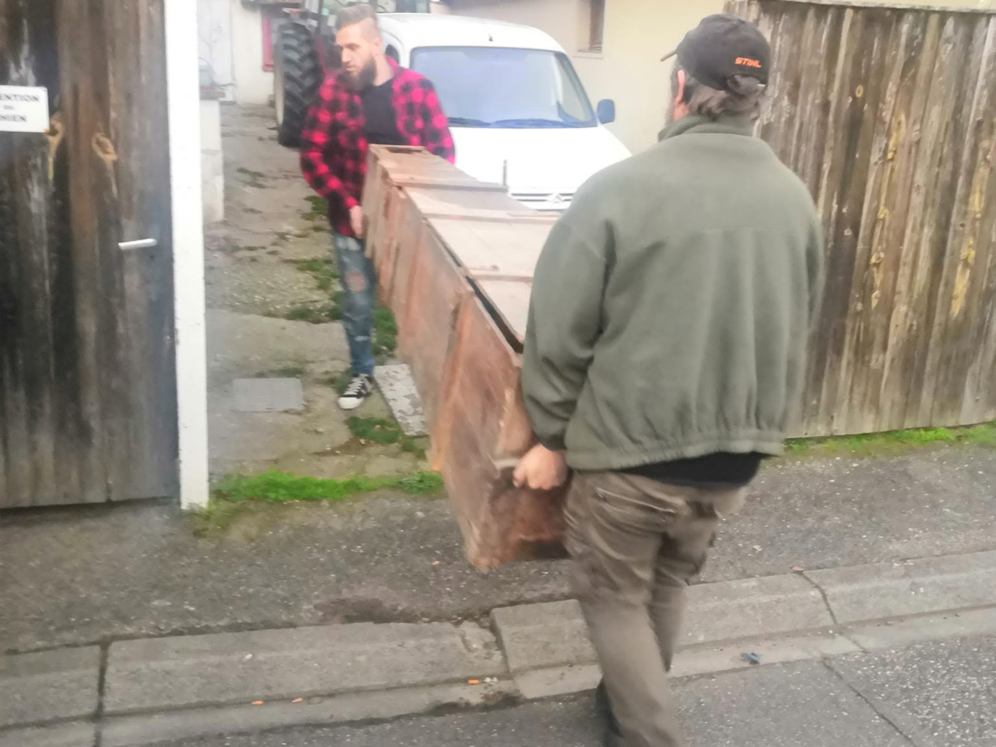 Manu et Alexandre portant la tronçonneuse offerte
